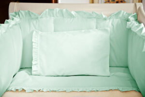 Juego de sábanas verde con boleros para cuna